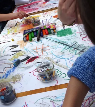 Gros plan sur une grande feuille où différents dessins ont été réalisés aux crayons pastel